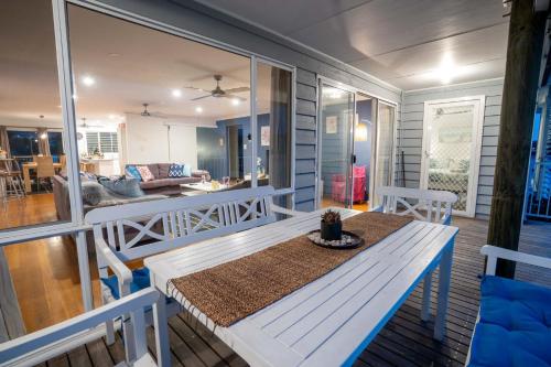 a porch with a table and a dining room at Shoal Bay Riggers - 7 Rigney St, Shoal Bay in Shoal Bay