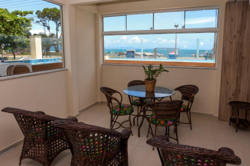a dining room with a table and chairs and a window at Pousada Roberto Monteiro - Frente Mar in Florianópolis