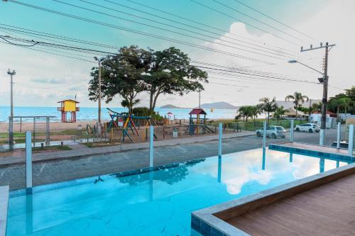uma piscina com vista para um parque infantil em Pousada Roberto Monteiro - Frente Mar em Florianópolis