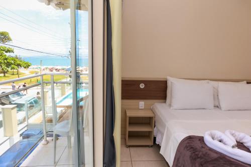 um quarto com uma cama e uma varanda em Pousada Roberto Monteiro - Frente Mar em Florianópolis