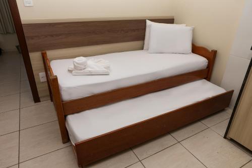 two beds in a room with a plate of food at Pousada Roberto Monteiro - Frente Mar in Florianópolis