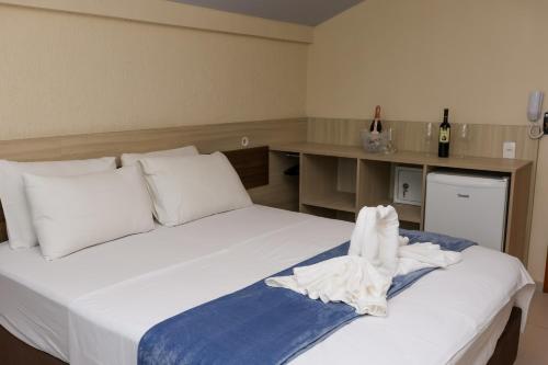 a bedroom with two beds with white sheets at Pousada Roberto Monteiro - Frente Mar in Florianópolis