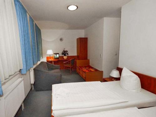 Habitación de hotel con cama, sofá y escritorio en Pension Mesogios en Bad Doberan