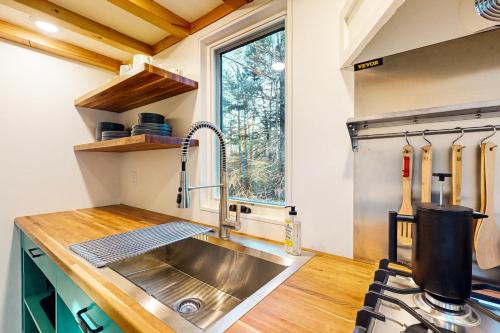 eine Küche mit einer Spüle aus Edelstahl und einem Fenster in der Unterkunft Thainy House in Gardiner