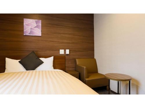 a hotel room with a bed and a chair at Sun Royal Kawasaki - Vacation STAY 98721v in Kawasaki