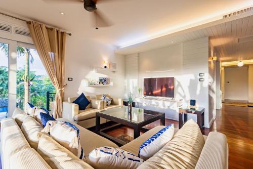 a living room with a couch and a tv at Le Azul - 3BR Beachfront HOME in Laguna & Layan Beach next KORA Resort in Phuket