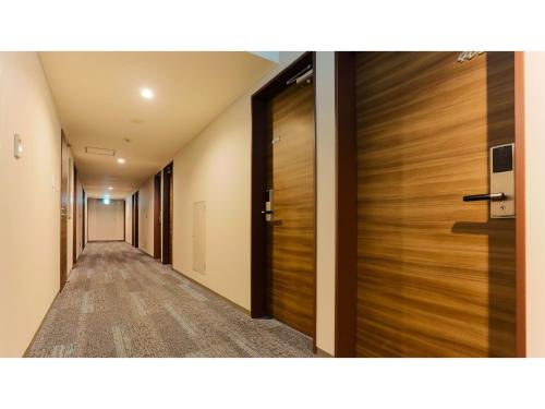 Un pasillo de un hotel con puertas de madera en Sun Royal Kawasaki - Vacation STAY 98734v, en Kawasaki