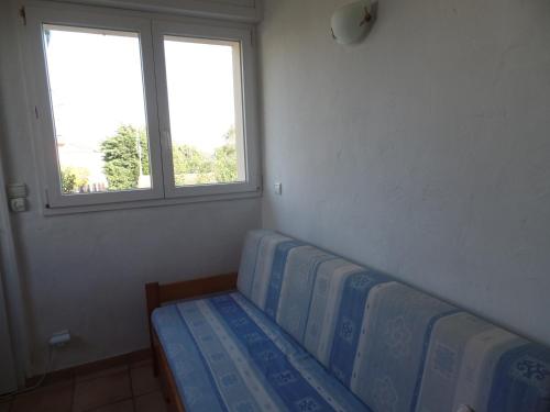 a room with a couch and two windows at Villa L'Adret et sa piscine in Juan-les-Pins