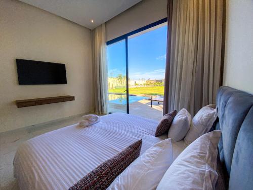 1 dormitorio con cama y ventana grande en Where Luxury Meets Marrakech villa & private Pool, en Marrakech