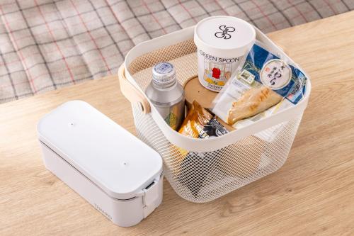 a basket with food and drinks and a cell phone at Tokyu Stay Aoyama Premier in Tokyo