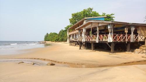 a building on the beach next to the ocean at Hôtel Restaurant Gites Kribi in Kribi