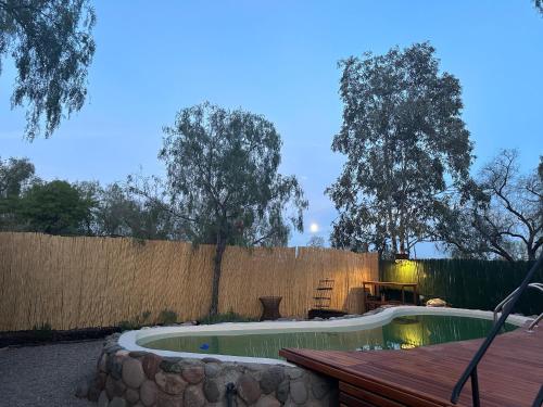 a swimming pool in a backyard with a fence at "Casa La Martina" naturaleza, sol y cielo in Chacras de Coria