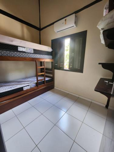 Cette chambre comprend 2 lits superposés et une fenêtre. dans l'établissement Residencial Kahunas II, à São Sebastião