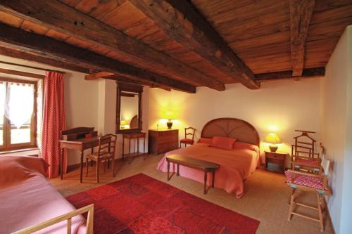 a bedroom with a bed and a table and a desk at Le masbareau, gite le vieux domaine in Royères-Saint-Léonard
