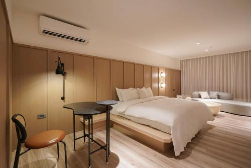 a hotel room with a bed and a table and a desk at Hope Hotel Tainan in Tainan