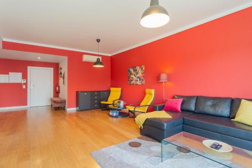 a living room with a couch and a red wall at LDapartments - Spacious Lisbon Haven w/Lift&Garage in Lisbon