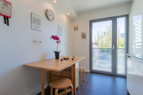 a dining room with a table and a clock on the wall at LDapartments - Spacious Lisbon Haven w/Lift&Garage in Lisbon