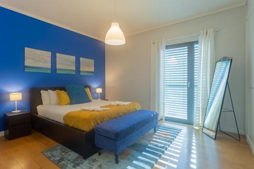 a bedroom with a bed and a blue wall at LDapartments - Spacious Lisbon Haven w/Lift&Garage in Lisbon