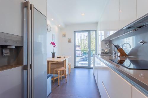 a kitchen with white counters and a table with a desk at LDapartments - Spacious Lisbon Haven w/Lift&Garage in Lisbon