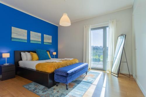 a bedroom with a bed and a blue wall at LDapartments - Spacious Lisbon Haven w/Lift&Garage in Lisbon