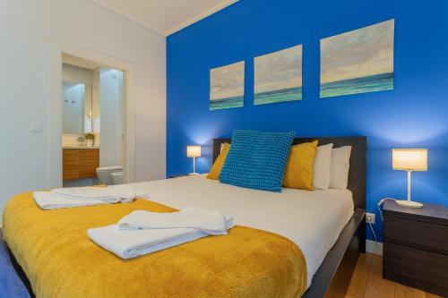 a blue bedroom with a bed with towels on it at LDapartments - Spacious Lisbon Haven w/Lift&Garage in Lisbon