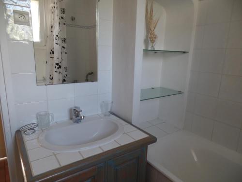 uma casa de banho branca com um lavatório e uma banheira em Villa L'Adret et sa piscine em Juan-les-Pins
