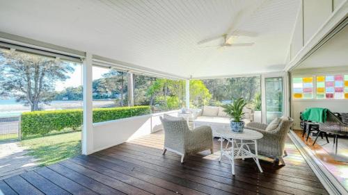 a living room with a table and chairs on a porch at 'Reverie' by HolidayCo in Hardys Bay