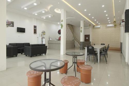 un vestíbulo con 2 mesas, sillas y una mesa en grand koetaradja permai hotel, en Luengbata