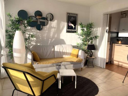 un salon avec un canapé blanc et des chaises dans l'établissement Appartement cosy à Bénodet, 4 pers, plage à 260m, parking privé - FR-1-481-151, à Bénodet