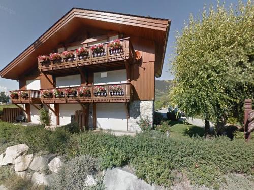une maison avec un balcon fleuri dans l'établissement Charmant appartement 4 pers au pied des pistes à Courchevel Le Praz - FR-1-568-49, à Courchevel