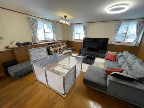 ein Wohnzimmer mit einem Sofa und einem Tisch in der Unterkunft No1 Private Hotel&Villa Aomoril 186平米貸切 最大12名 in Aomori