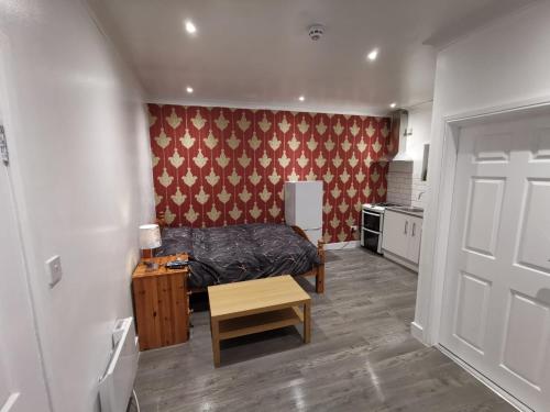 a bedroom with a bed and a table and a door at Studio Apartment near Luton Airport and Luton Central in Luton