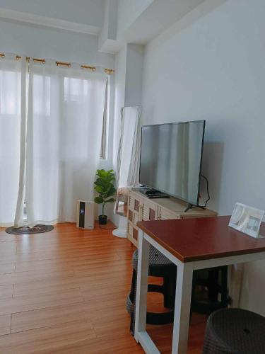 a living room with a flat screen tv and a table at Arabella Transient Home in Baguio