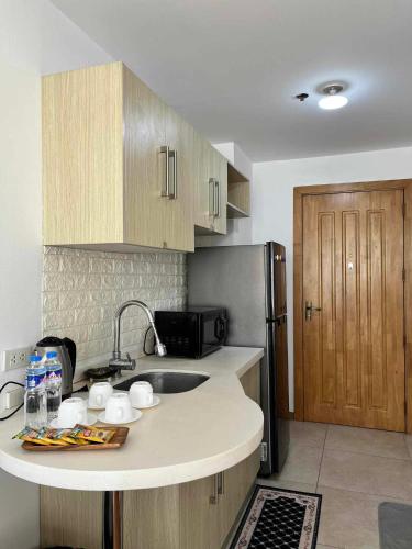 a kitchen with a sink and a refrigerator at Arabella Transient Home in Baguio