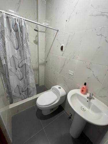 uma casa de banho branca com um WC e um lavatório em MIHAHI BEACH em Máncora