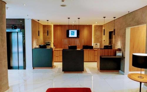 a large room with a kitchen with wooden cabinets and a tv at The Best Urban Deluxe - Duplex Studio - Hotel QLTY Faria Lima - by LuXXoR in Sao Paulo