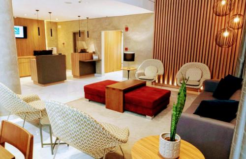 a living room with a couch and tables and chairs at The Best Urban Deluxe - Duplex Studio - Hotel QLTY Faria Lima - by LuXXoR in Sao Paulo