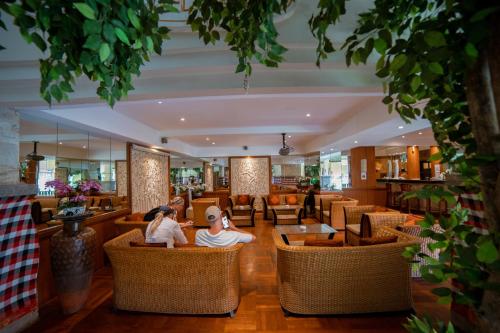 two people sitting in the lobby of a restaurant at Pelangi Bali Hotel & Spa in Seminyak