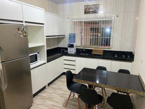 uma cozinha com uma mesa e cadeiras e um frigorífico em Casa de praia em Penha em Penha