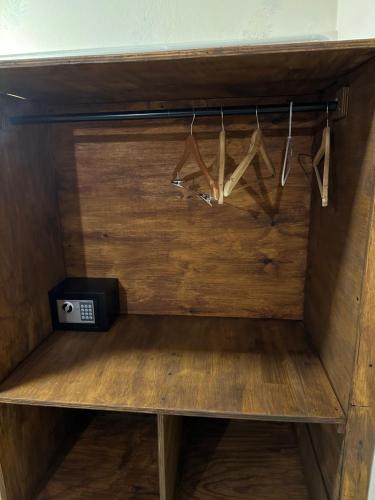 ein Holzregal mit Kleiderbügeln in einem Zimmer in der Unterkunft Room in El Chalten