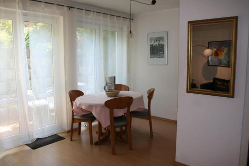 ein Esszimmer mit einem Tisch mit Stühlen und einem Spiegel in der Unterkunft Ferienwohnung am Schlosspark in Weinheim