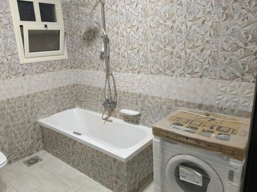 a bathroom with a washing machine and a sink at شقة بالجيزة in Cairo