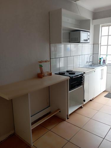 uma cozinha com um fogão e uma bancada em Yakhe Self-catering Accommodation in Edenvale Johannesburg em Edenvale