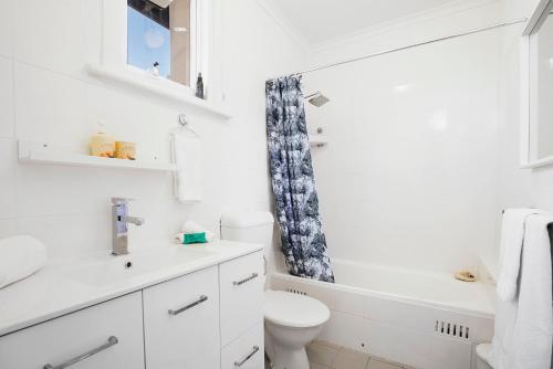 een witte badkamer met een toilet en een wastafel bij Seaview No 6 Henley Beach Wifi in Henley Beach South