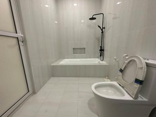 a white bathroom with a toilet and a bath tub at Lavender seenu feydhoo addu city in Feydhoo