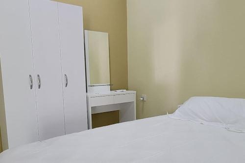 biała sypialnia z łóżkiem i lustrem w obiekcie Lavender seenu feydhoo addu city w mieście Feydhoo