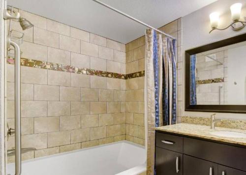 y baño con bañera, lavamanos y ducha. en Weekends in May and June - Amazing Deluxe 1-Bedroom - Next to Sphere in Las Vegas!, en Las Vegas