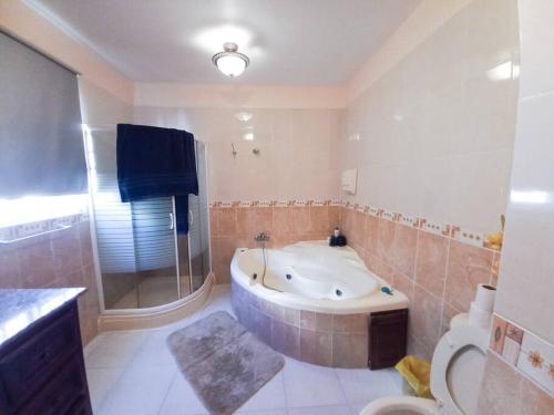 a large bathroom with a tub and a toilet at La Romana Vacation Home in Cumayasa Kilómetros 4 1/2