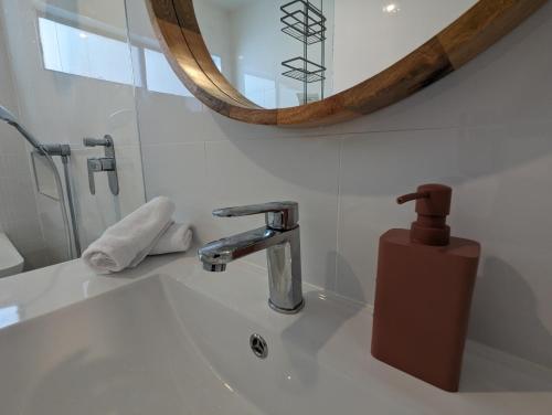 a bathroom sink with a faucet and a mirror at 2 bedroom apartment with Garden views in Sydney in Sydney