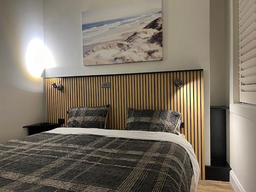 Schlafzimmer mit einem Bett mit einem Kopfteil aus Holz in der Unterkunft Location Location Executive Apartment in Sydney